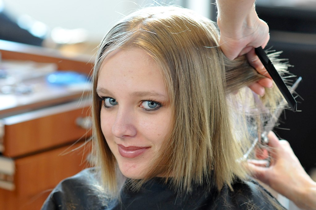 a lady getting her hair cut