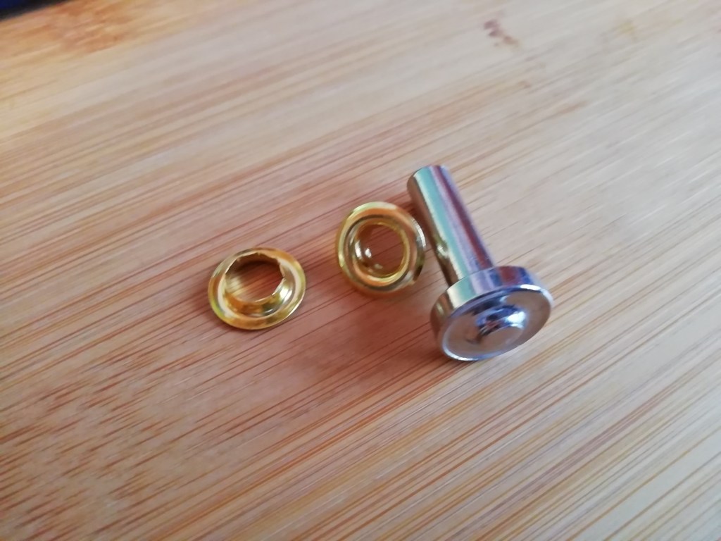 Two eyelets and an eyelet setter.