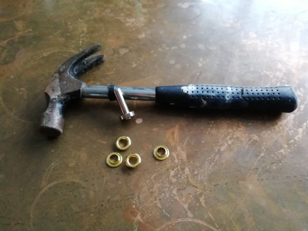 A hammer, two eyelets, and an eyelet tool.