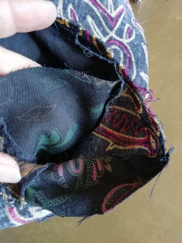 The sleeve sits inside the sleeve hole, in preparation for being sewn back on.