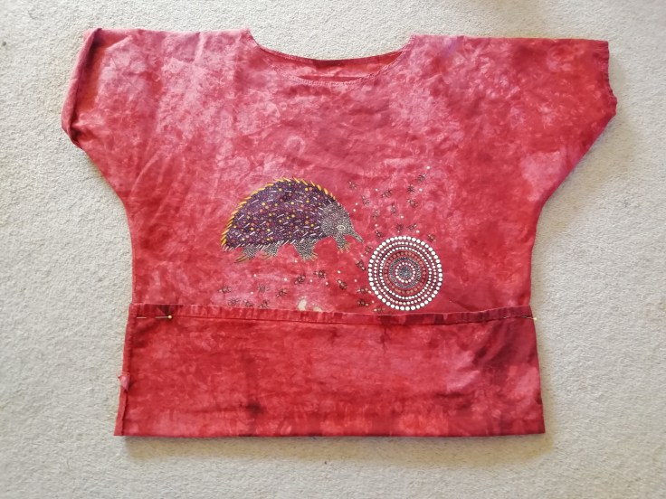 A t-shirt with the hem folded up and pinned.