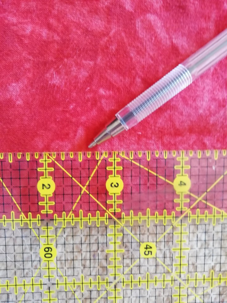 A ruler measures the cut line one inch below the fold.